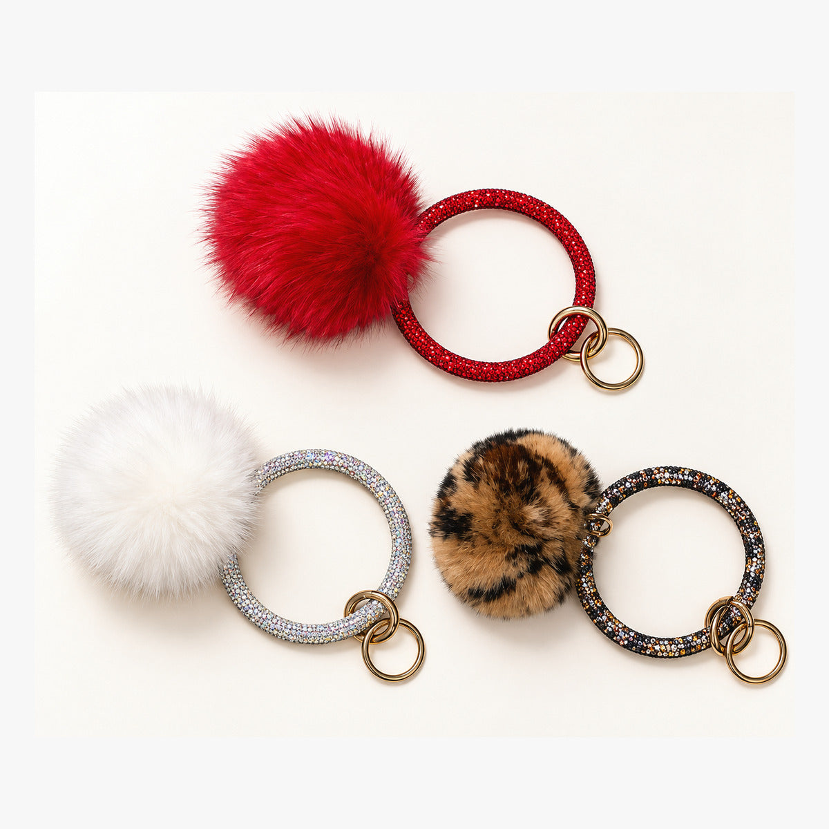 Red, white, and leopard print pom keychains with sparkling circular handles