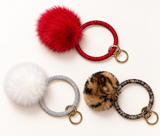Red, white, and leopard print pom keychains with sparkling circular handles